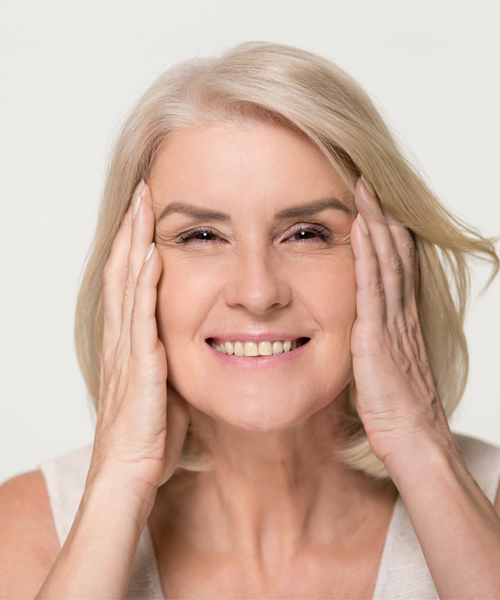 Mujer senior sonriente estirándose la cara